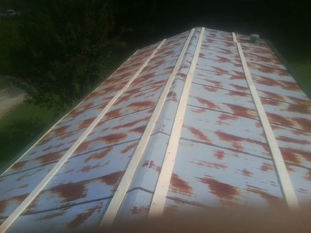 Rusted metal roof panels with new wood purlins before replacement — Storm Damage Roof Repair in North Hollywood by Roofing Brothers